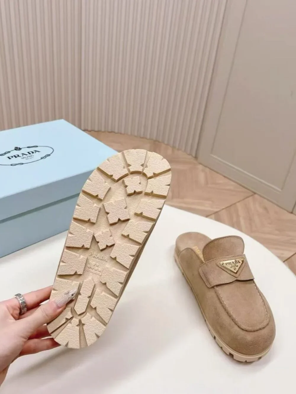 Prada beige slip‑on mules with triangular logo badge